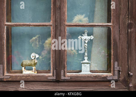 Jesus Christus am Kreuz und Lamm Figur in alten Holz- Fenster Stockfoto