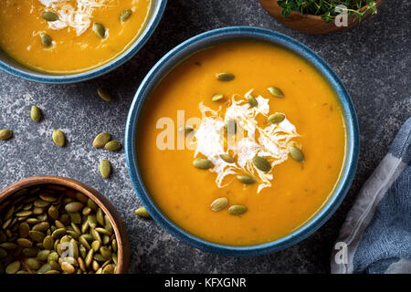 Köstliche cremige selbstgemachte Kürbissuppe mit Sahne und Kürbiskerne garnieren. Stockfoto