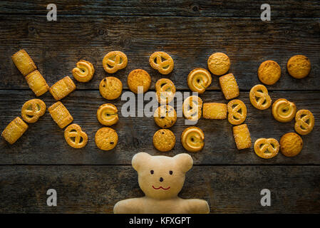 Tabelle Top Shot von Lebkuchen Cookies wie Buchstaben xmas auf hölzernen Hintergrund geprägt. Weihnachten Konzept Stockfoto