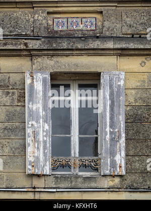 Altes verwittertes Holzfenster mit Fensterläden in Steinwand Stockfoto