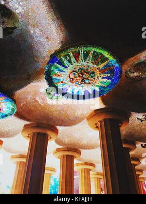Trencadis Mosaik aus zerbrochenen Fliesen Scherben an der Decke der großen Säulenhalle Zimmer im Park Güell, Barcelona, Katalonien, Spanien. Stockfoto