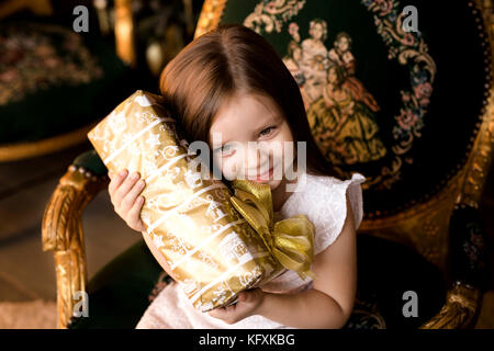 Wenig lächelnde Mädchen mit Weihnachtsgeschenk. Stockfoto