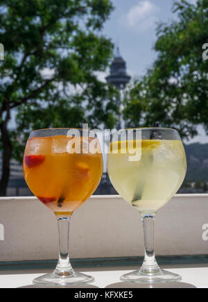 Sangria orange und gelb Cocktail Drinks auf Gläsern mit Strohhalmen. Bis auf kalten alkoholischen Getränken mit Eis zu schließen, in Scheiben geschnittene Erdbeeren in Barcelona. Stockfoto