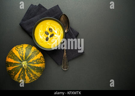 Kürbis- und Gemüsesuppe mit Sahne auf dunklem Hintergrund der Ansicht von oben Stockfoto