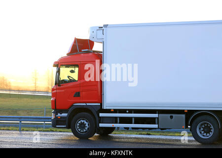 Red Temperaturgeregelte Ladung Fahrzeug durch einen Truck Stop ist bereit, am Morgen bei Sonnenaufgang zu gehen. Stockfoto