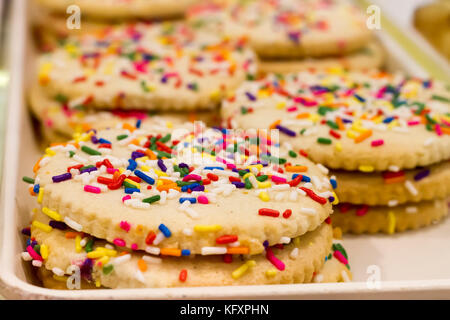 Nahaufnahme des goldenen Cookies mit winzigen rainbow Streuseln. Soft Focus Stockfoto