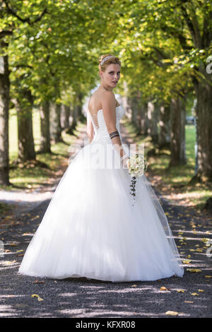 Junge blonde Frau in einem weißen Brautkleid, Schweiz Stockfoto