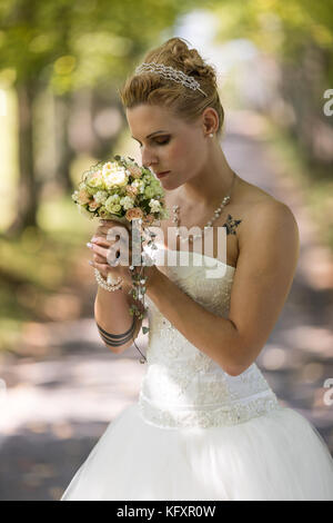 Junge blonde Frau in einem weißen Brautkleid, Schweiz Stockfoto