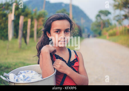 Pena Blanca, Honduras - Mai 6, 2015: lokale Mädchen trägt mit einem Topf von Tortillas in einem kleinen Dorf von Kaffeebauern in westlichen Honduras Stockfoto