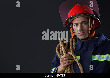 Portrait von Feuerwehrmann mit einem Seil Stockfoto