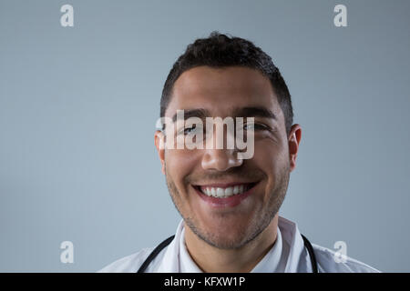 Portrait von lächelnden Arzt vor weißem Hintergrund Stockfoto