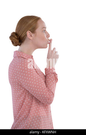 Schöne Frau mit dem Finger auf die Lippen auf weißem Hintergrund Stockfoto