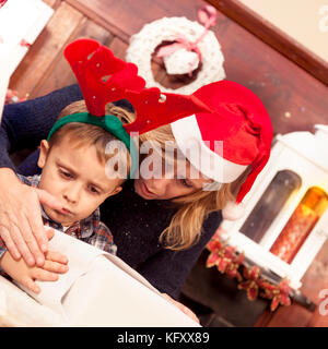 Schöne kleine Junge bereitet Weihnachtsgeschenke mit ihrer Mutter Stockfoto