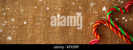 Schnee gegen herzförmige Zuckerstange auf Auf Gewebe Stockfoto