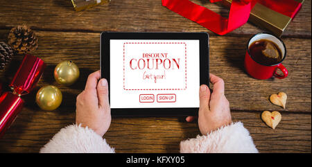 Verkauf Anzeige gegen santa claus Holding digital Tablet Stockfoto
