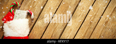 Schnee gegen hohe Betrachtungswinkel von verpackten Geschenk Box und Candy Cane, die an der Vorratshaltung auf Tisch während der Weihnachtszeit Stockfoto