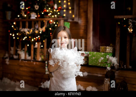 Frohe Weihnachten und schöne Feiertage. Kleines Mädchen in Weihnachten Dekor Stockfoto