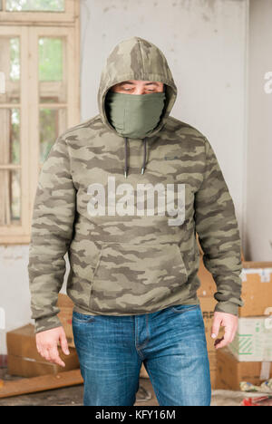 Mann portrait in Jeans und Camouflage in verlassenen Sanatorium - Krankenhaus Zimmer Stockfoto