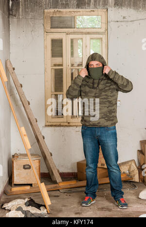 Mann portrait in Jeans und Camouflage in verlassenen Sanatorium - Krankenhaus Zimmer Stockfoto