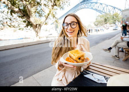 Frau mit francesinha Essen in Porto Stockfoto