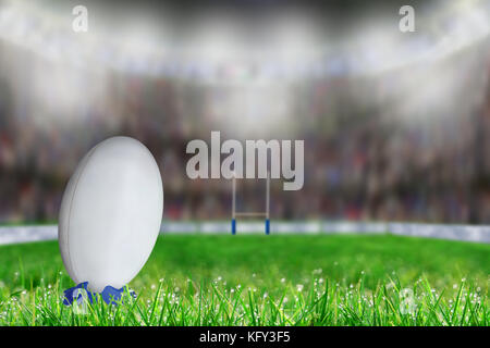 Low Angle Blick auf die weissen Rugby Ball in ein Kicking Tee auf dem Gras für den Umbau oder die Elfmeter Richtung Tor Post bereit. Geringe Tiefe von fi Vorsätzliche Stockfoto