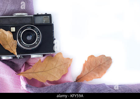 Vintage analog Foto Kamera in trockenen Ahorn leaveson weißen Hintergrund, Ansicht von oben Stockfoto