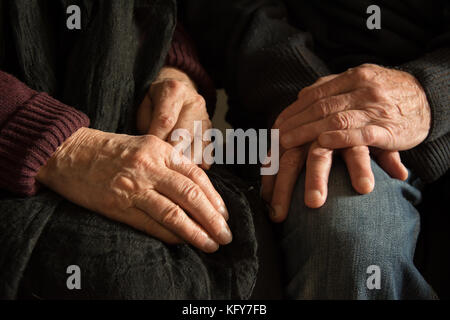Hände einer alten Frau und einen alten Mann sitzen zusammen Stockfoto