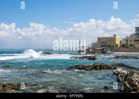 Küste in Reifen am Meer mit Wellen und mit Leuchtturm in Reifen, Sauer, Libanon Stockfoto
