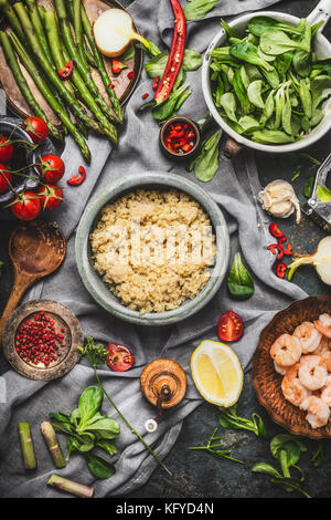 Blick von oben auf die gesunden Salat mit Spargel und gekocht Quinoa Samen, Vorbereitung auf rustikalen Hintergrund mit verschiedenen Bio-gemüse. vegetarische Kost Stockfoto