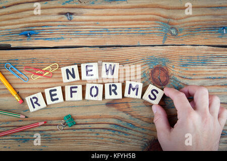 Neue Reformen. Holz- Buchstaben auf dem Schreibtisch Stockfoto