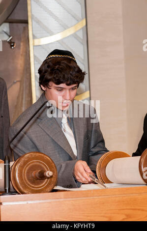 Minnetonka, Minnesota. 14-jähriger Junge, der für seine Bar Mitzvah in der Bet Shalom Congregation Synagogenda praktiziert. Lesen einer Tora-Schriftrolle mit einem yad. Stockfoto