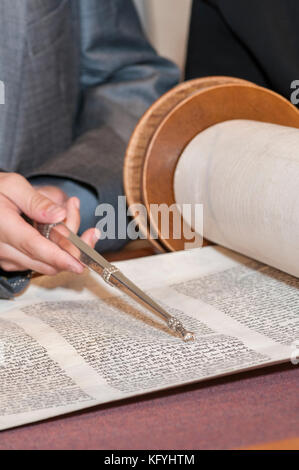 Minnetonka, Minnesota. 14-jähriger Junge, der für seine Bar Mitzvah in der Bet Shalom Congregation Synagogenda praktiziert. Lesen einer Tora-Schriftrolle mit einem yad. Stockfoto