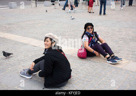 Asain Frauen Mutter und Tochter sitzen und Foto bei Innenhof der Kathedrale Notre-Dame de Paris in Paris, Frankreich Stockfoto