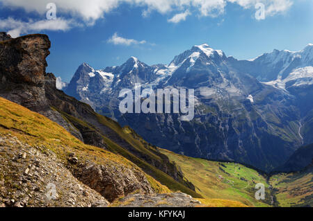 Blick auf die Wiese auf Schilthorn, die Dörfer Schiltalp und Gimmeln darunter, Eiger, Mönch und Jungfrau im Hintergrund, Schweiz Stockfoto