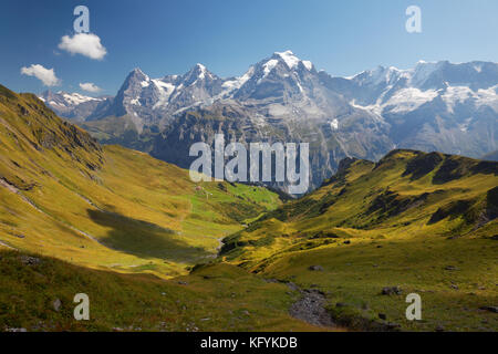 Blick auf die Wiese auf Schilthorn, die Dörfer Schiltalp und Gimmeln darunter, Eiger, Mönch und Jungfrau im Hintergrund, Schweiz Stockfoto