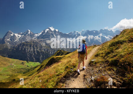 Mädchenwanderweg am Wasenegg am Schilthorn, unten die Dörfer Schiltalp und Gimmeln, Eiger, Mönch und Jungfrau im Hintergrund, Schweiz Stockfoto