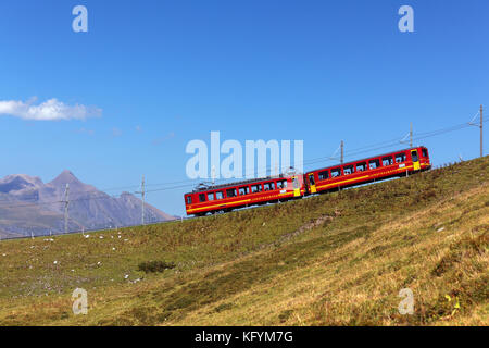 Rote Eisenbahnwaggons auf der Jungfrau-Bahn, Berner Oberland, Schweiz Stockfoto