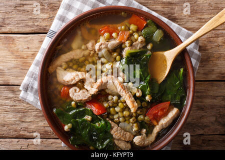 Philippinische Mung Bohnen Suppe mit Schweinefleisch closeup in einer Schüssel auf den Tisch. horizontal oben Ansicht von oben Stockfoto