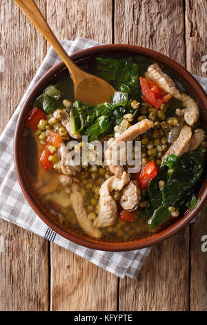 Philippinische Mung Bohnen Suppe mit Schweinefleisch closeup in einer Schüssel auf den Tisch. Senkrechte Draufsicht von oben Stockfoto