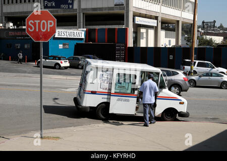 United States Postal van und mailman auf einer Straße Ecke im Echo Park, Los Angeles, Kalifornien USA KATHY DEWITT Stockfoto