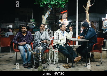 Hurghada, Ägypten - 27. Dezember 2014. Einheimische ägyptische Männer genießen Tee und Shisha auf einer Straße in Hurghada. Stockfoto