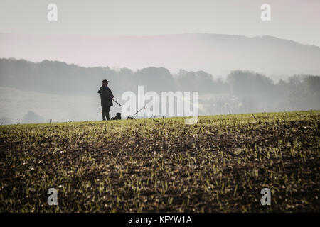 Herr an seine Peg in einen Drei-tage-Feld auf Fasan schießen auf einem nebligen Morgen, Hampshire, England warten. Stockfoto