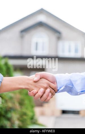 Immobilienmakler und Client die Hände schütteln Stockfoto