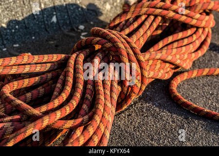 Nahaufnahme rot geflochtenem Seil auf Asphalt Stockfoto