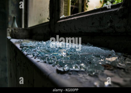 Einige Scherben auf einer Wand in einem Raum eines verlassenen psychiatrischen Krankenhaus Stockfoto