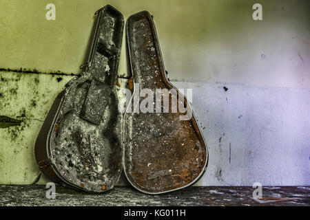 Eine E-Gitarre auf einem Tisch vollständig verbrannt, in einem Raum eines verlassenen psychiatrischen Krankenhaus Stockfoto