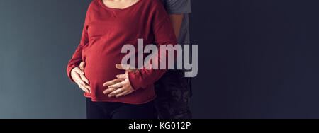 Soldat seine schwangere Frau umarmen, paar Baby erwarten Stockfoto