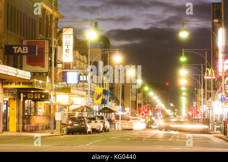 Ein Abendhimmel über Hindley Street, Adelaide, South Australia, wie ein Auto in eine Parklücke zieht. Stockfoto