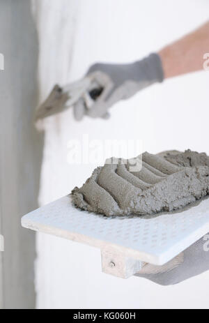 Close-up of construction worker holding a hand cement plaster Stockfoto