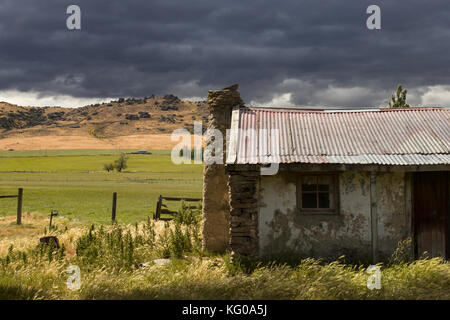 Eine verlassene Hütte unter Gathering Storm clouds in die catlins, Neuseeland Stockfoto